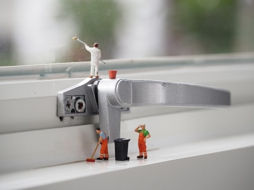 Photograph shows minature figurine people cleaning a window