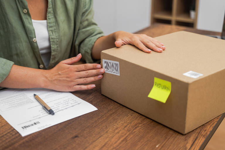 A woman sticks a label onto a parcel